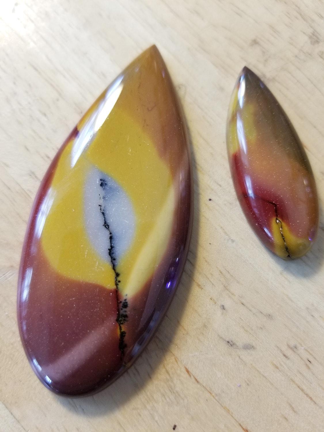 Teardrop shaped mookite cabochons in reds, yellow, white, and black