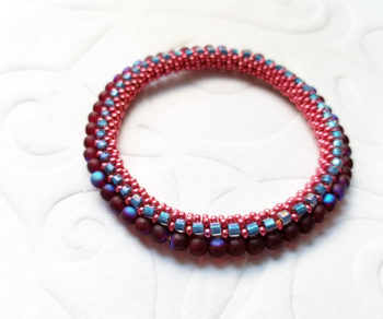 Red metallic bead crochet bracelet with blue cubes and irredescent 4mm round beads