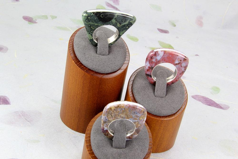 Three polished stone rings with opal channel inlay