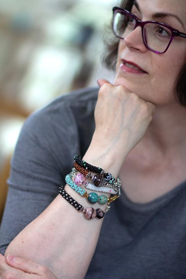 Photo of Susan Jefferson wearing a stack of bead crochet bracelets with sterling silver clasps