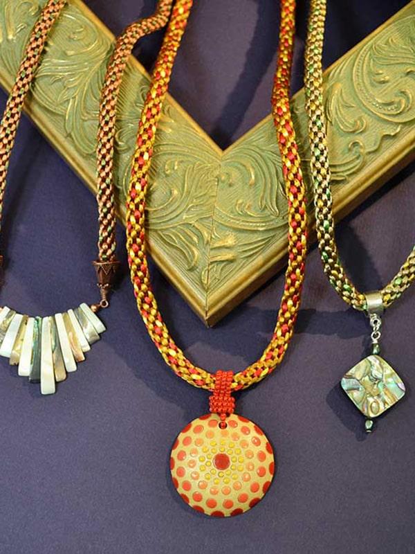 Examples of kumihimo braids in multiple colors with semi-precious stone pendants