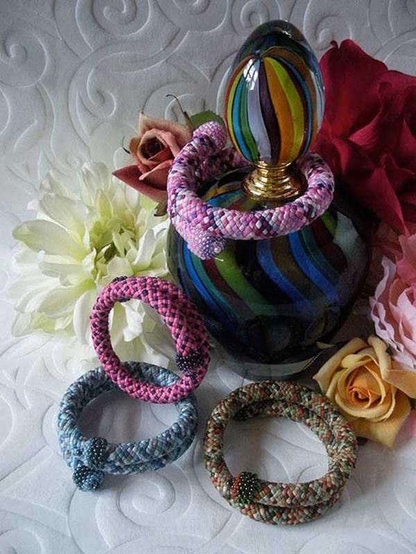 Beautiful vase used as a backdrop for several spiral kumihimo bracelets in the basketweave pattern