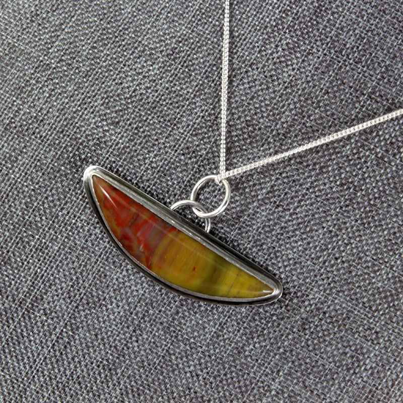 Petrified wood from AZ fashioned into a mezzaluna or half-moon shaped pendant in sterling silver.