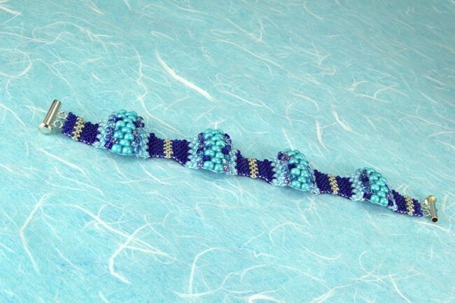 Peyote stitch bracelet with multiple size beads in various shades of tealPeyote stitch bracelet with multiple size beads in various shades of blue and silver
