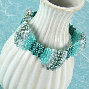 Peyote stitch bracelet with multiple size beads in various shades of teal
