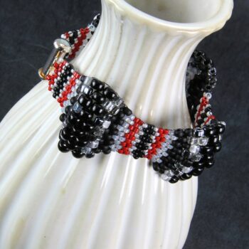 Peyote stitch bracelet with multiple size beads in black, red, and grey