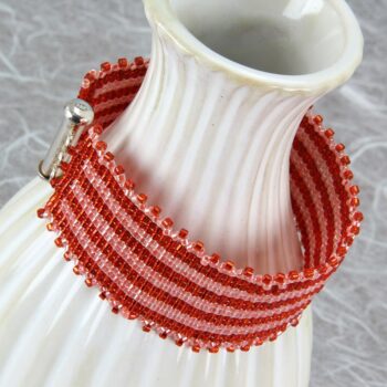 Square stitch beaded bracelet with orange ribbon pattern